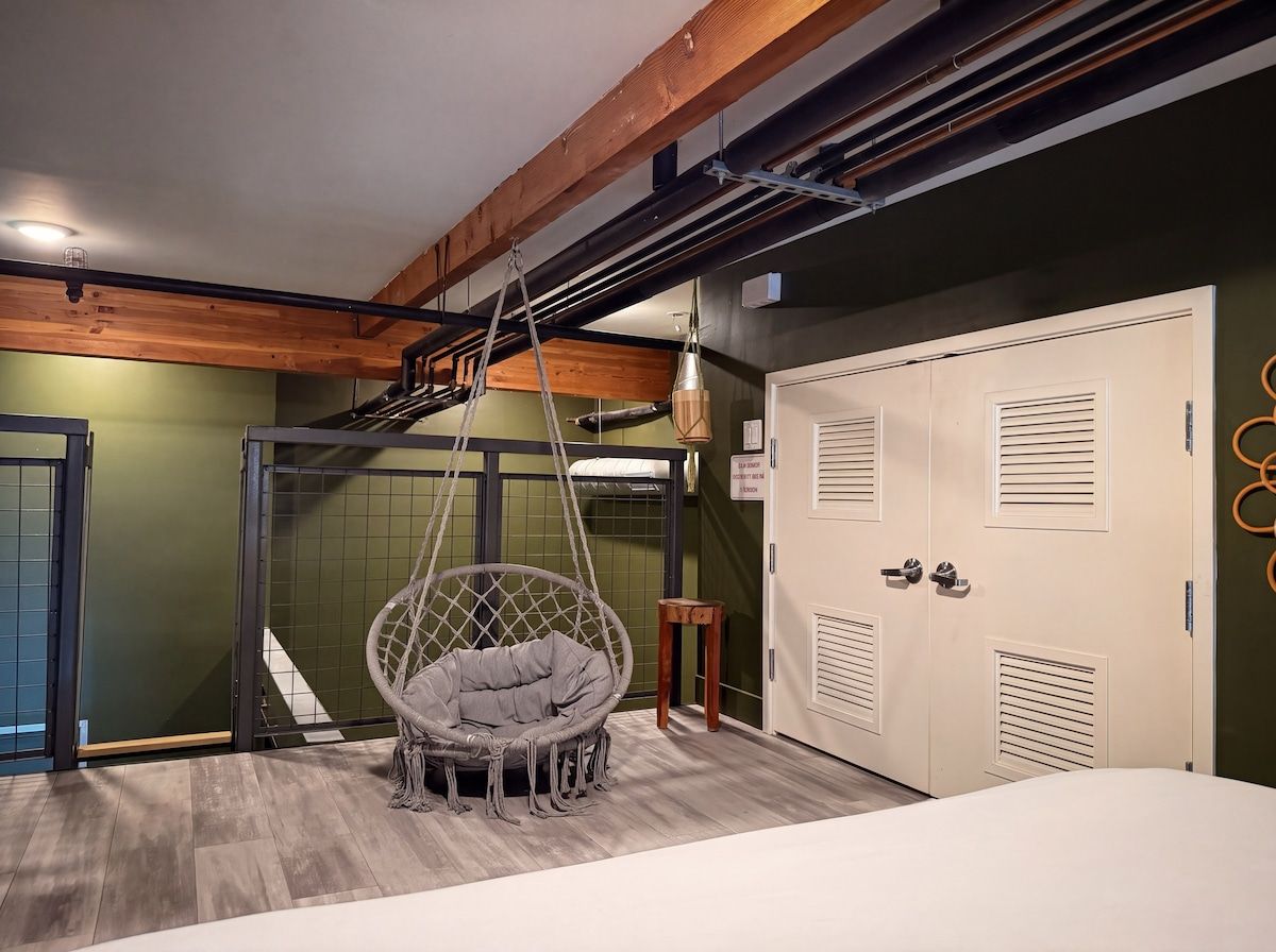 Une pièce avec un fauteuil suspendu, une armoire et une porte sur laquelle est apposée une pancarte.