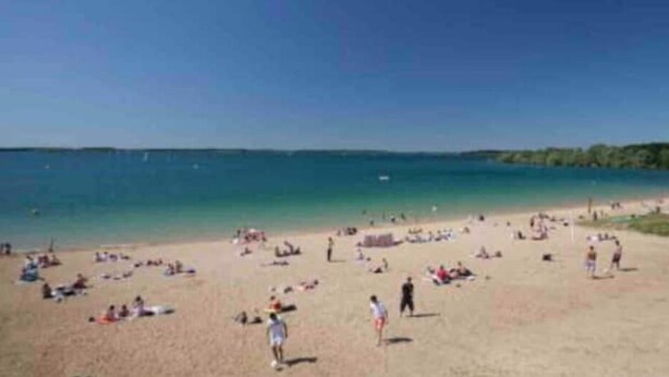 Ein Strand mit Menschen, die sich sonnen und schwimmen.