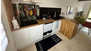 Eine moderne Küche mit weißen Schränken, einer schwarzen Arbeitsplatte und einer Edelstahl-Dunstabzugshaube.