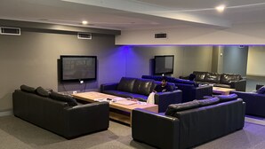 Un salon moderne doté d’un téléviseur à écran plat, de canapés en cuir et d’une table basse.