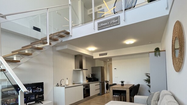 Un appartement moderne comprenant un salon, une cuisine et un balcon.