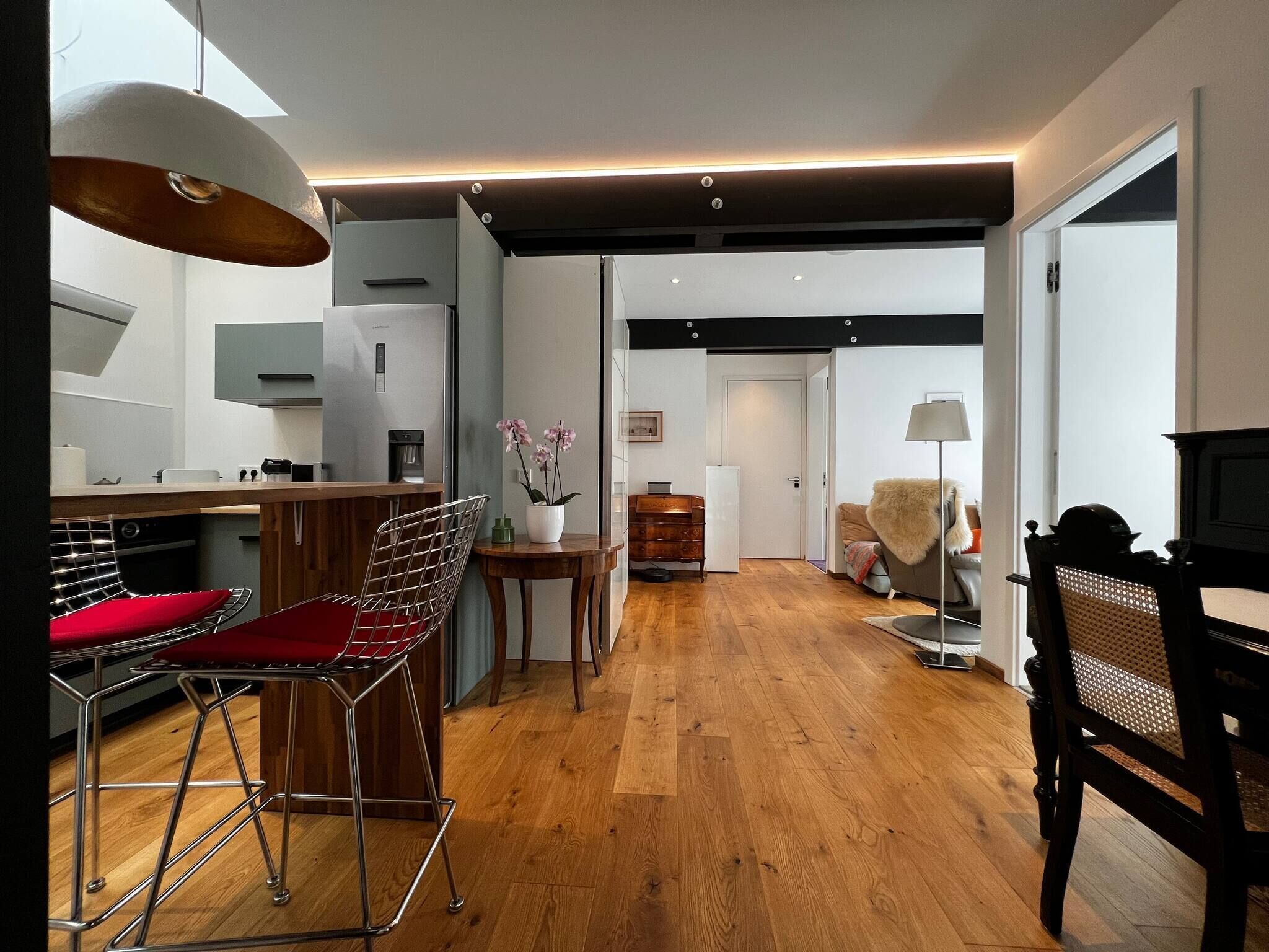Eine moderne Küche mit Essbereich, Holzboden und Blick zum Wohnzimmer.