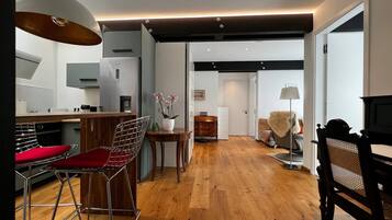 Eine moderne Küche mit Essbereich, Holzboden und Blick zum Wohnzimmer.