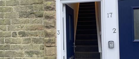 A staircase leading to a blue door with the number 17, adjacent to a white door with the number 3.
