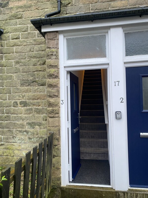 A staircase leading to a blue door with the number 17, adjacent to a white door with the number 3.