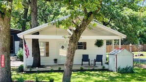 A single-story house with a covered porch, a small shed, and a well-maintained lawn.