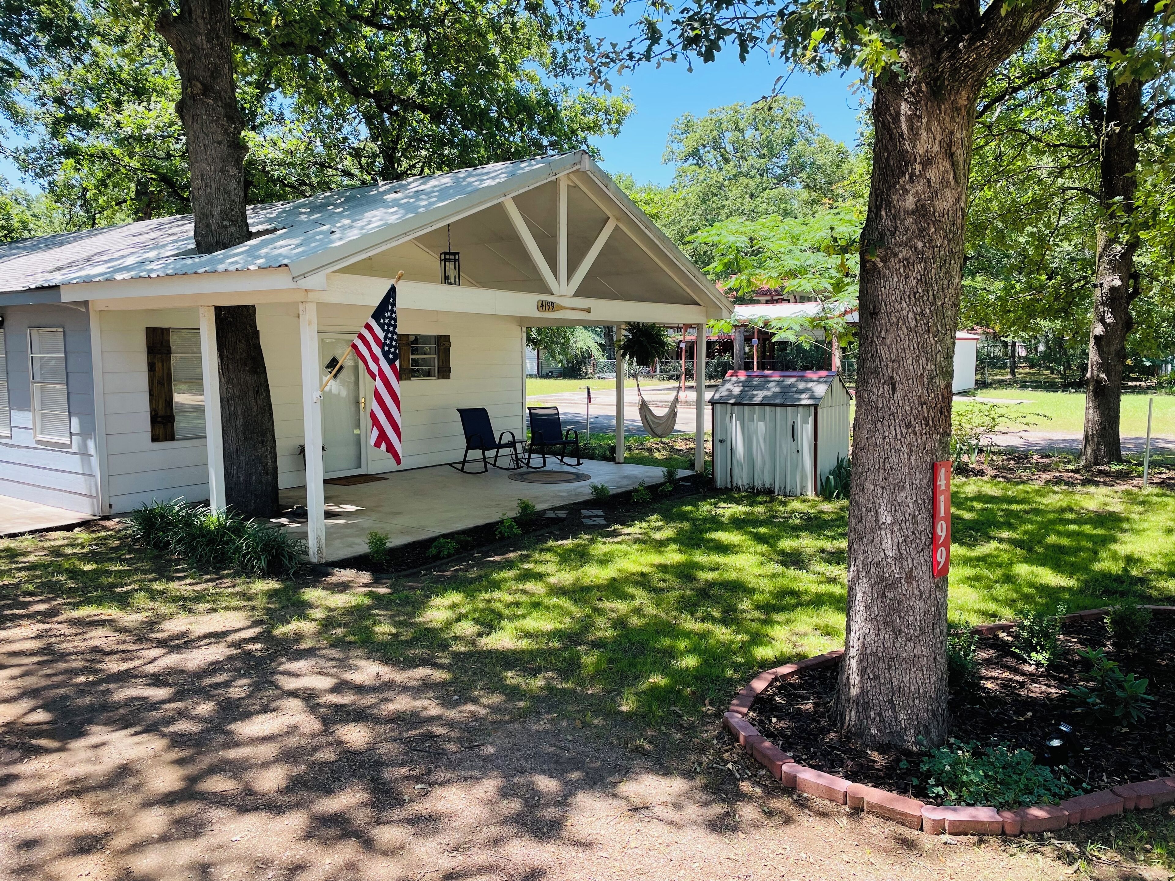 Een klein, laag gebouw met een veranda, een Amerikaanse vlag en een brievenbus.