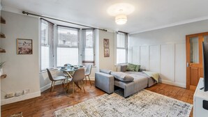 En moderne stue med spiseområde, store vinduer og hyggelig siddeplads.