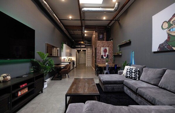 A modern living room with a sectional sofa, a flat-screen TV, and a coffee table.