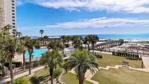 A resort with a pool, palm trees, and a beach.