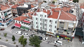 A multi-story building with commercial spaces on the ground floor, including a hotel and various shops. - PLUSCITY HOTEL (Konya)