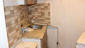 A small kitchen with a sink, a cabinet, and a tiled backsplash. - Remarkable 1-bed Apartment in Thessaloniki (Thessaloniki)