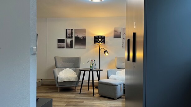 A modern living room with a grey armchair, a small round table, a floor lamp, and a sofa. - Top Apartment Zentrum Bad Urach 5 Minutes to Train Station (Bad Urach)
