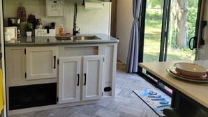Una cocina moderna con armarios blancos, una isla integrada y un amplio ventanal con vistas al exterior.