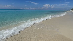 Una playa con aguas turquesas cristalinas y una orilla arenosa.