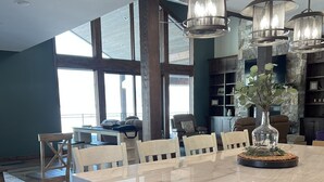 A modern kitchen with a large island, wooden cabinets, and pendant lighting. - New Luxurious waterfront cabin on Henry's Lake. 26 minutes to West Yellowstone  (Island Park)