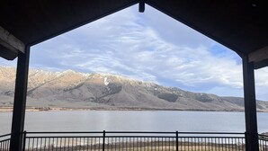 A covered outdoor area with a view of a lake and mountains. - New Luxurious waterfront cabin on Henry's Lake. 26 minutes to West Yellowstone  (Island Park)