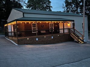 A wooden building with a porch, a staircase, and a railing. - Grand Rivers, KY ~ Unit B ~ Cozy & Charming ~ near Kentucky & Barkley Lake (Grand Rivers)