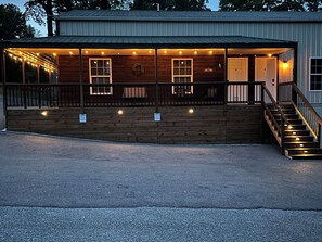 A wooden building with a porch, a staircase, and a 'Welcome' sign.