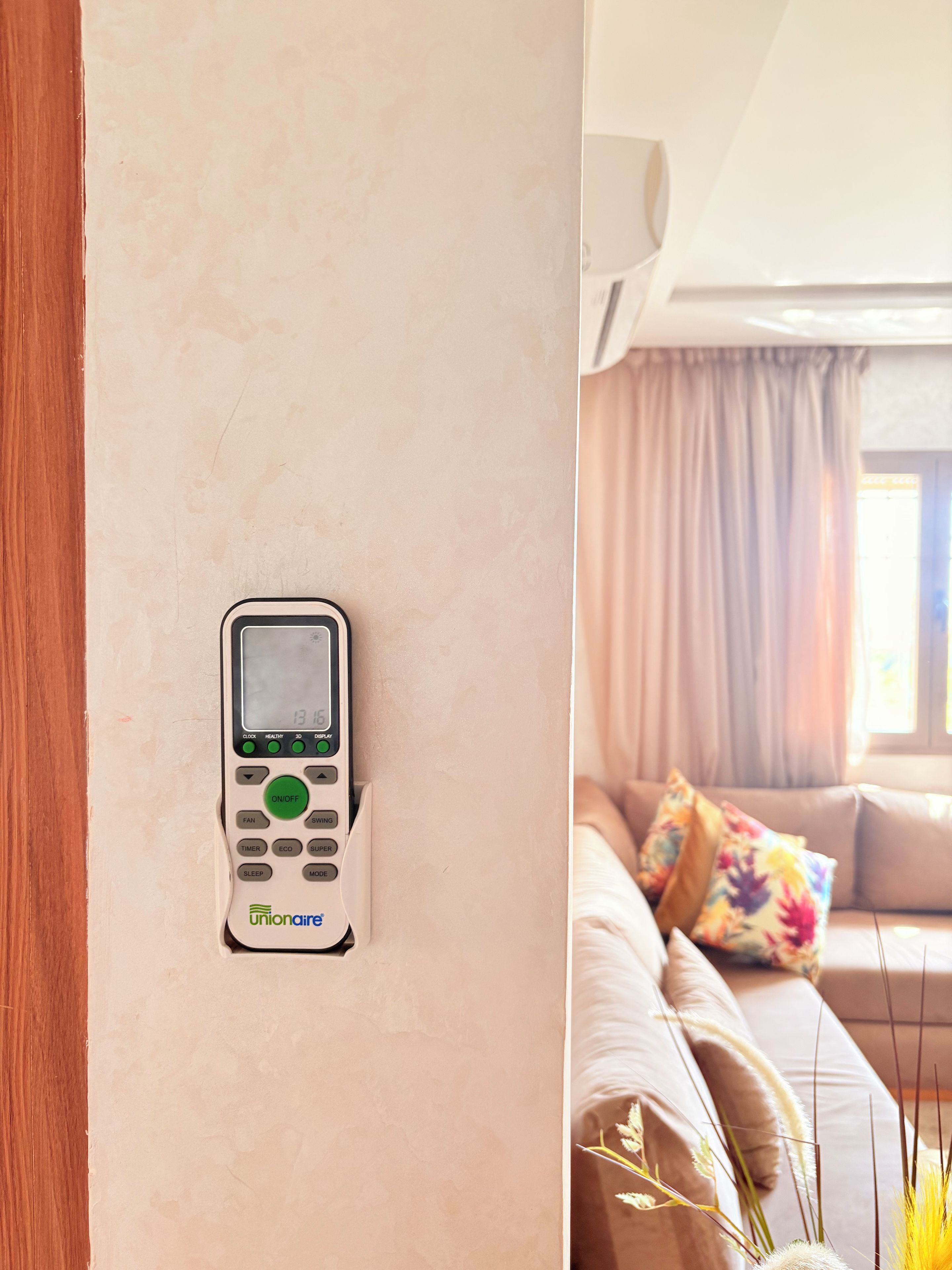 A wall-mounted air conditioning unit with a digital display and control buttons.