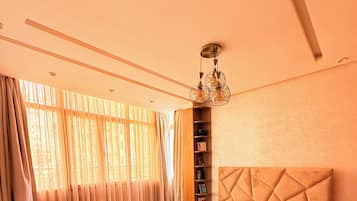 Un dormitorio con una cama grande, una estantería y una lámpara en el techo.