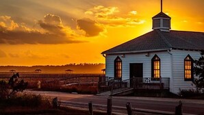 A white church with a cross on the roof, a porch, and a view of the sunset. - Spacious 4 Bedroom, 3 Bath Condo in Pawleys Island: 2-minute drive to pvt beach (Pawleys Island)