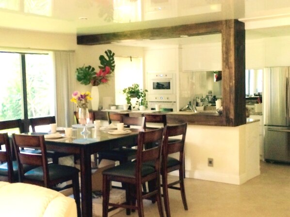 A modern kitchen with white cabinets, a stainless steel refrigerator, and a built-in oven.
