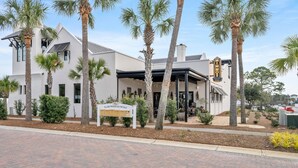 A modern building with a sign indicating 'Village Properties for Sale'. - Highly Rated Cozy 30A Blue Mountain Beach Escape! (Santa Rosa Beach)