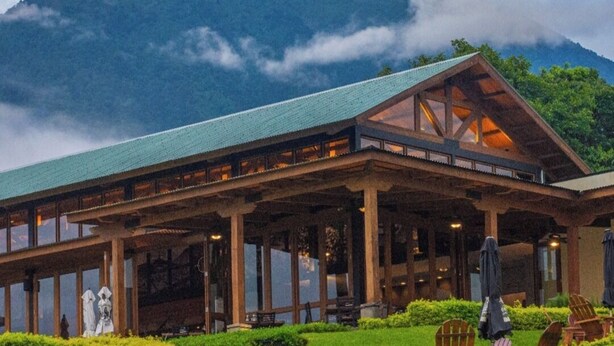 A lodge with a large open patio, wooden beams, and a mountain backdrop. - Finca San Cayetano (Alotenango)
