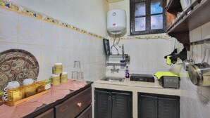 A kitchen with a water heater, a window, and various kitchen items on the counter.