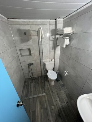 A compact bathroom with a toilet, a shower, and a sink. - prestij apart otel (Marmaris)