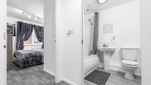 A modern bathroom with a shower, toilet, and sink. - Stunning 2-bed Apartment in Tipton Sleeps 3 (Tipton)