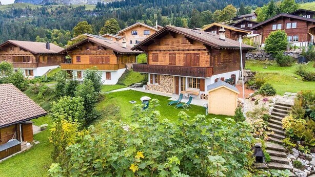 A cluster of wooden houses with a mountain backdrop.