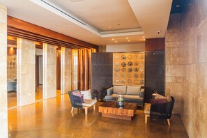 Eine Lobby mit Holzbude, Sitzgelegenheiten und einer Wand mit kreisförmigen Mustern.