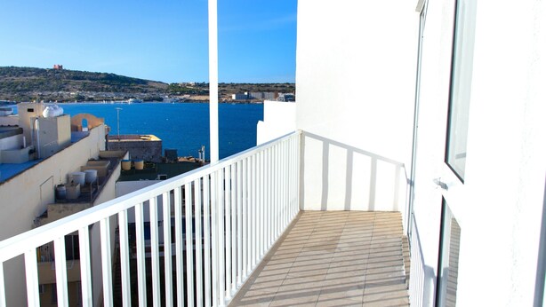 A balcony with a view of the sea and a distant hill. - Seaside Serenity - Luxe Penthouse - near the beach (Il-Mellieha)