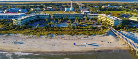 Ett hotell vid kusten med flera byggnader, en strand och en brygga.