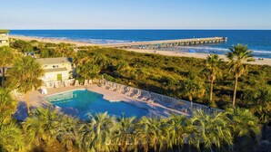 Un resort con piscina, playa y muelle.