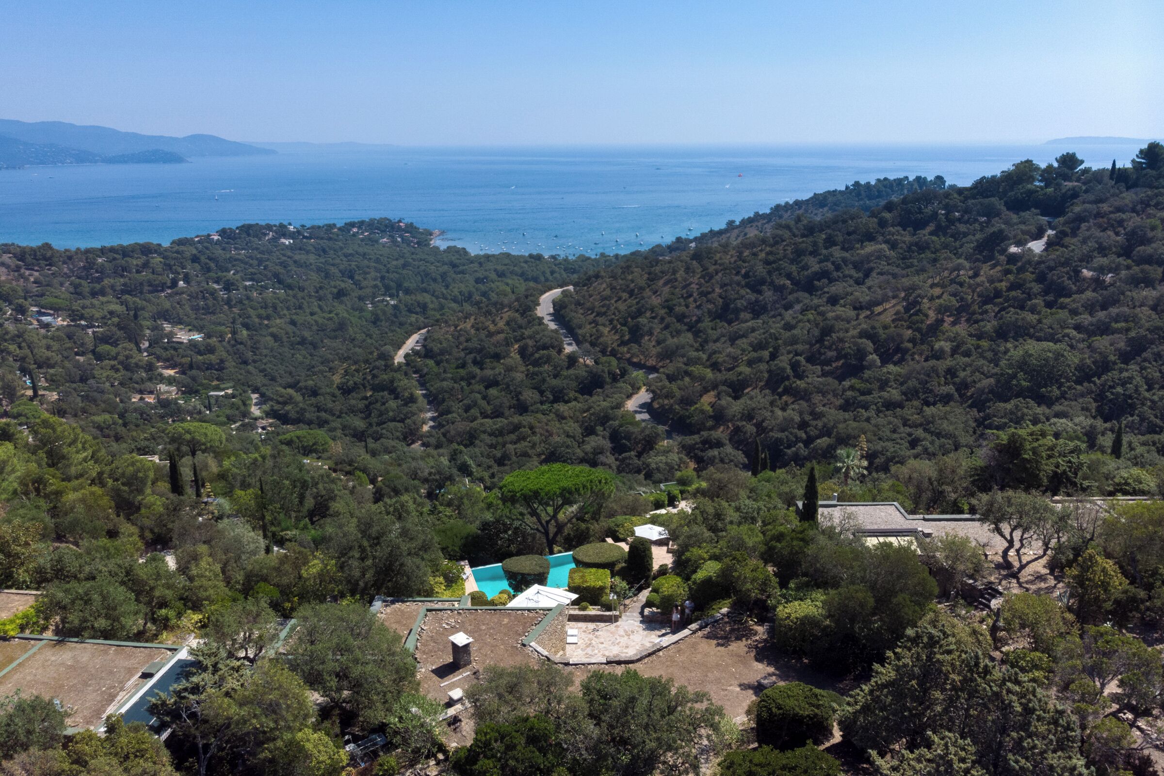 Une propriété située sur la côte, dotée d’une piscine, entourée d’une forêt dense et offrant une vue dégagée sur la mer.