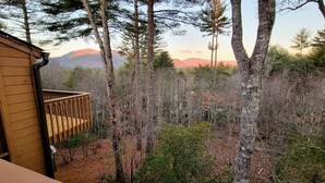 A wooden deck with a view of a forest and distant mountains. - Sapphire Mountain View Escape: Resort Amenities, Family & Pet Friendly! (Sapphire)