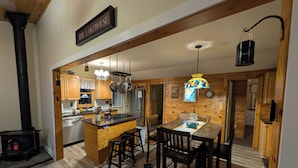 Interior de madera con cocina, comedor y un cartel que dice 'THE LAKEHOUSE'.