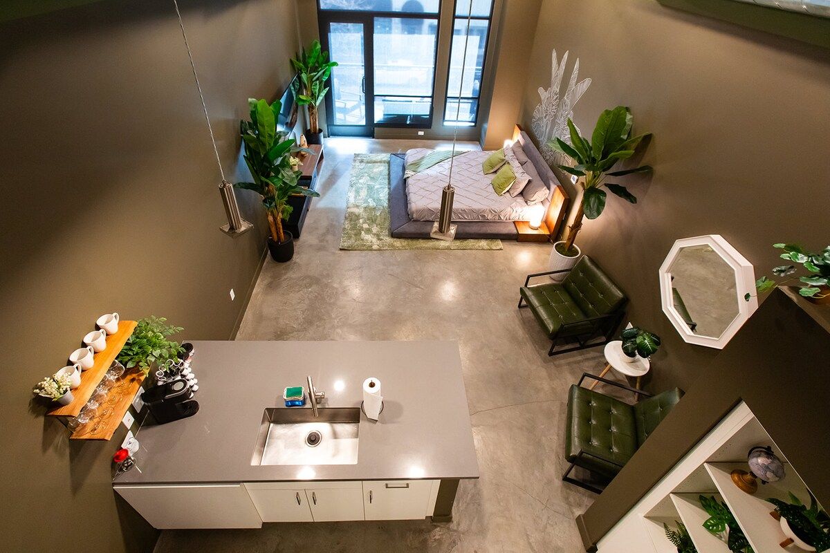 A modern interior with a kitchen island, seating area, and a bed.