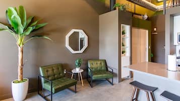 A modern interior with a bar area, seating, and a large potted plant.