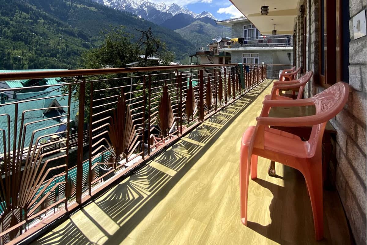 A balcony with a view of mountains and a lake.