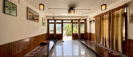 A hallway with wooden benches, a tiled floor, and a ceiling fan.