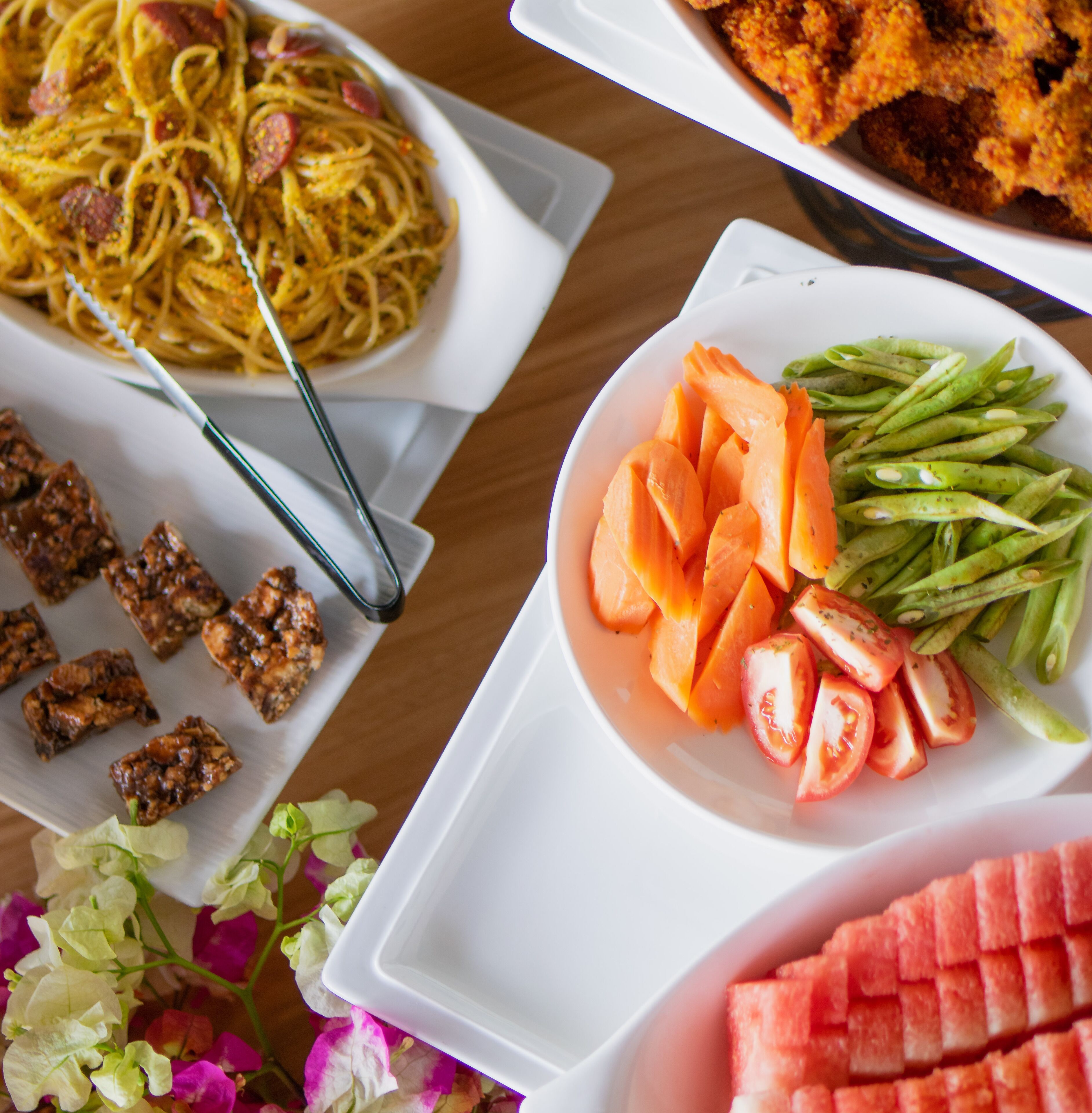 A variety of dishes including pasta, meat, and vegetables on a table.