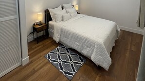 A bedroom with a bed, a ceiling fan, a nightstand with a lamp, and a patterned rug. - Home away from home, has all the amenities you need to have a comfortable stay. (Saint Bernard)