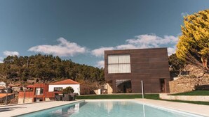 A modern building with a pool in front.