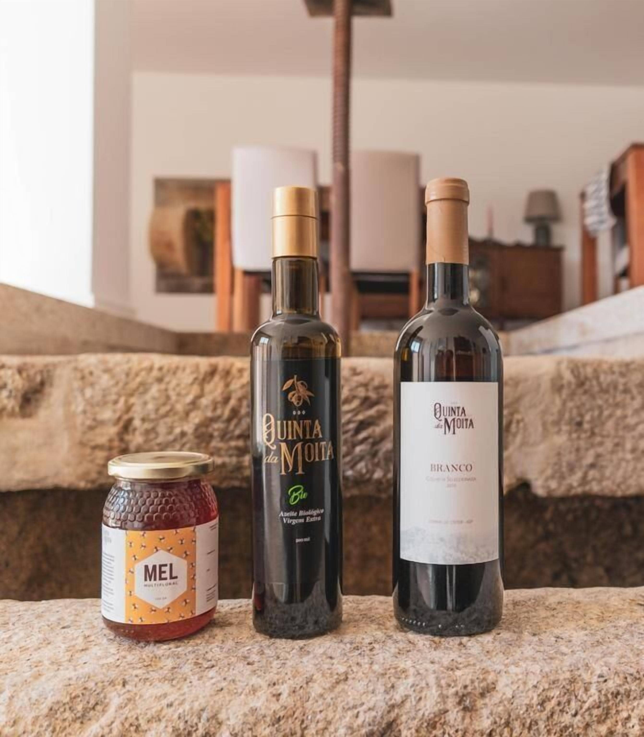 Three bottles of Quinta da Moita wine on a stone ledge.