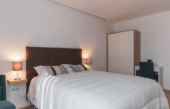 A modern bedroom with a large bed, two bedside lamps, a desk, and a wardrobe. - Quinta da Moita Agroturismo (Tabuaço)