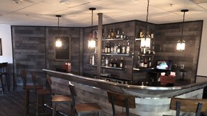 A bar area with a counter, stools, and shelves of bottles. - INTERNATIONAL dr/UNIVERSAL 2 BEDROOMS KING SUITE with free parking  (Orlando)